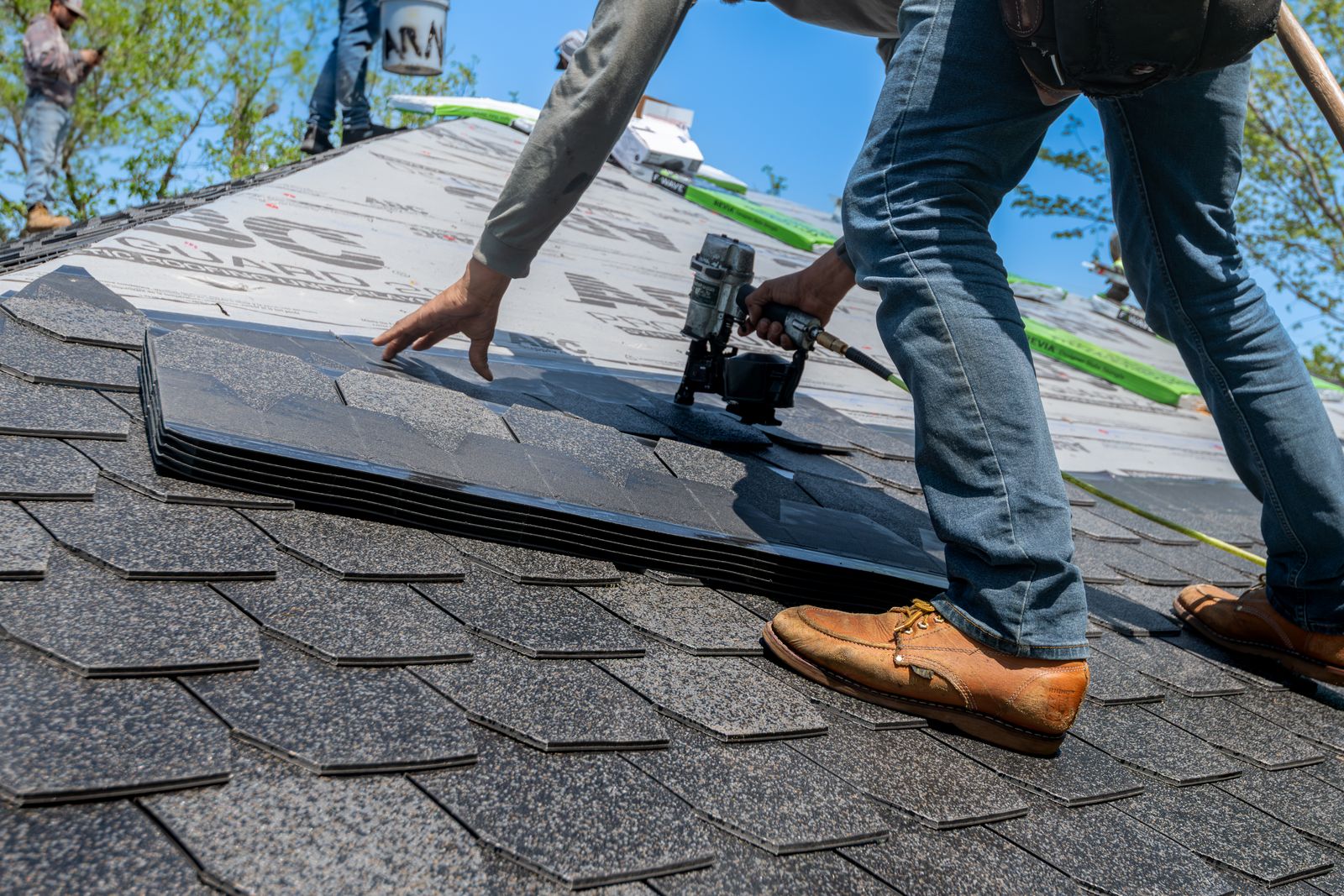 Roofer fitting new shingles on a residential roof