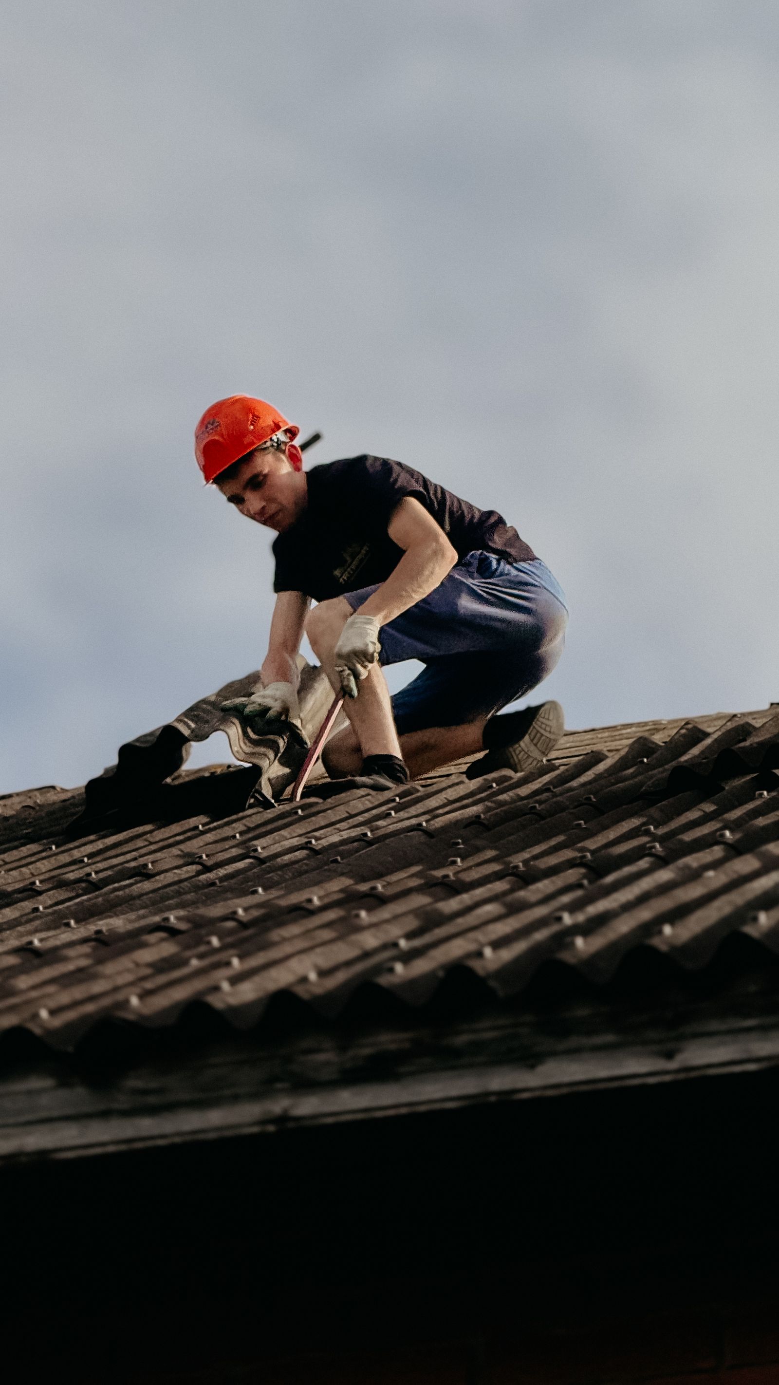 Roofer repairing damaged shingles